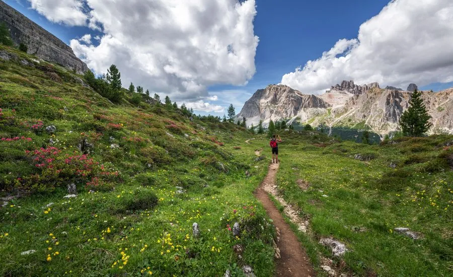 A walker on a mountain path above a valley